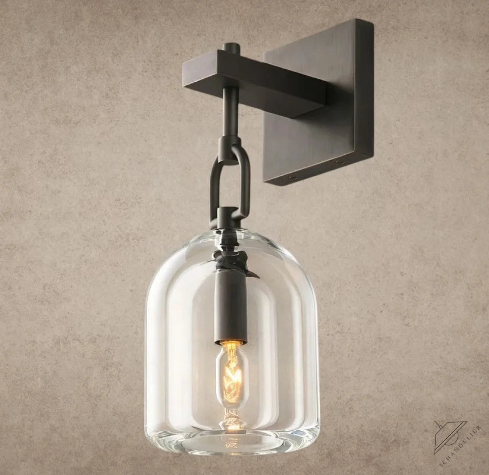 ichandelier Botanist Cloche Sconce, clear glass shade with dark metal hardware and exposed Edison bulb.