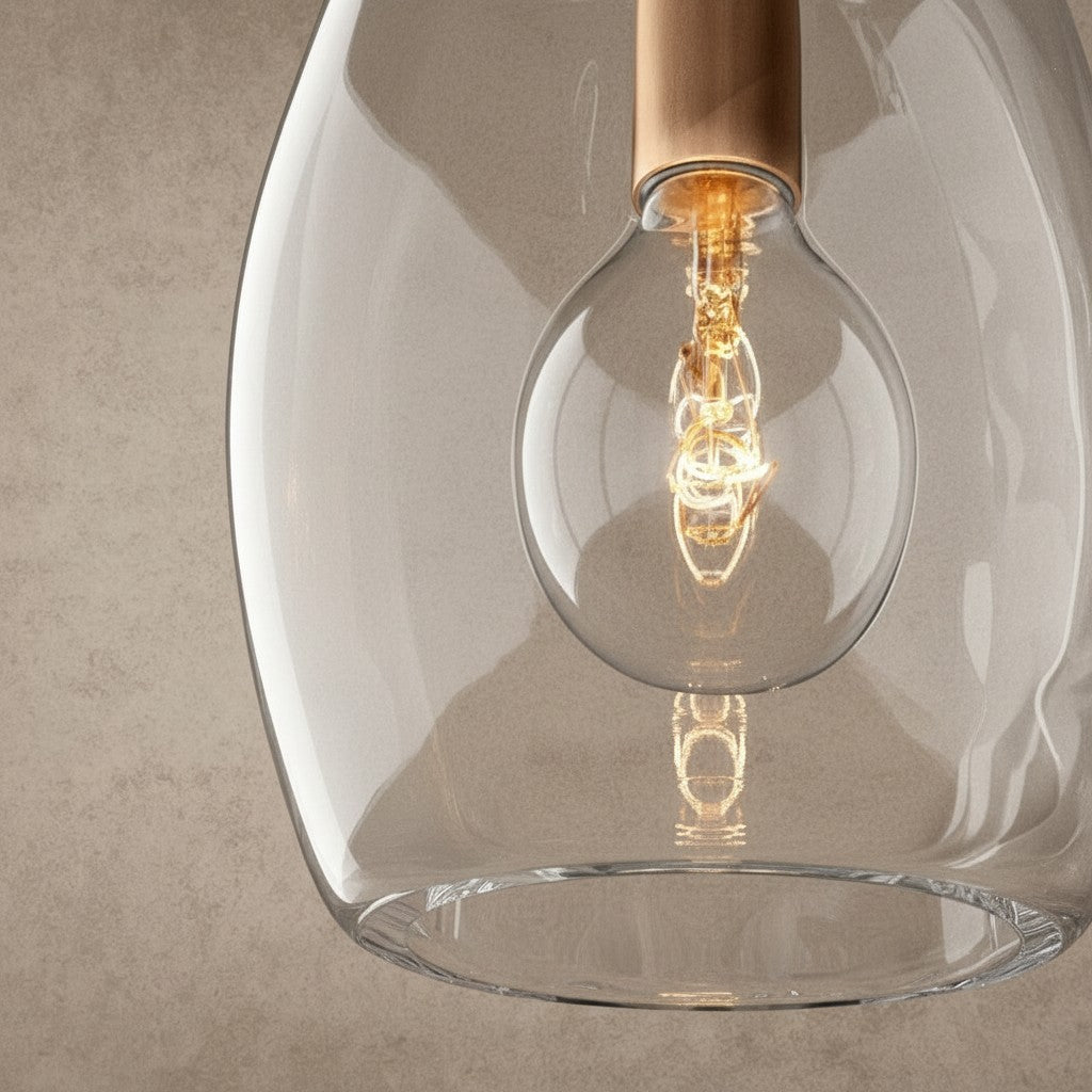 ichandelier Botanist Flute Pendant, clear glass shade with a copper accent and exposed filament bulb.