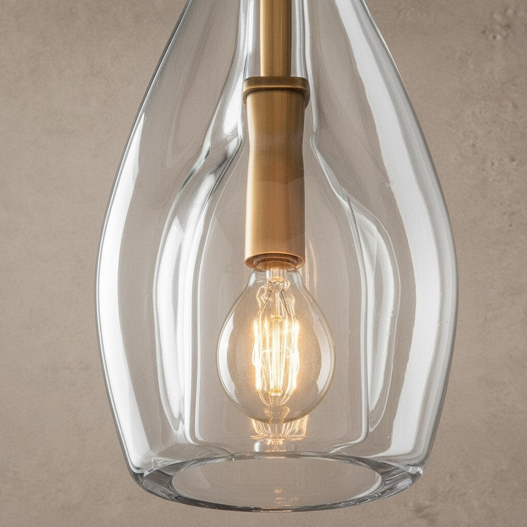 ichandelier Botanist Flute Sconce, clear glass pendant light with brass accents and exposed Edison bulb.
