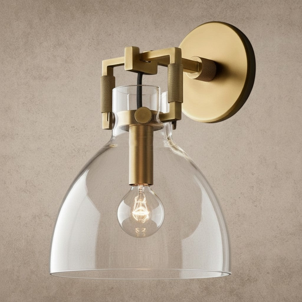 ichandelier Machinist-Glass-Cloche-Sconce, a brass wall sconce with a clear glass bell shade and exposed Edison bulb.