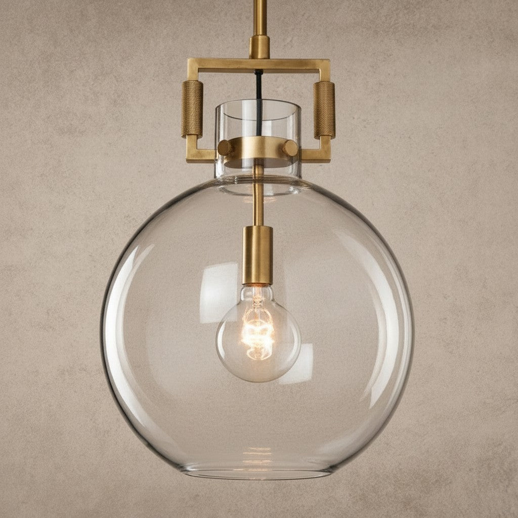 ichandelier Machinist-Glass-Globe-Pendant, a clear glass globe pendant light with brass hardware and exposed Edison bulb.