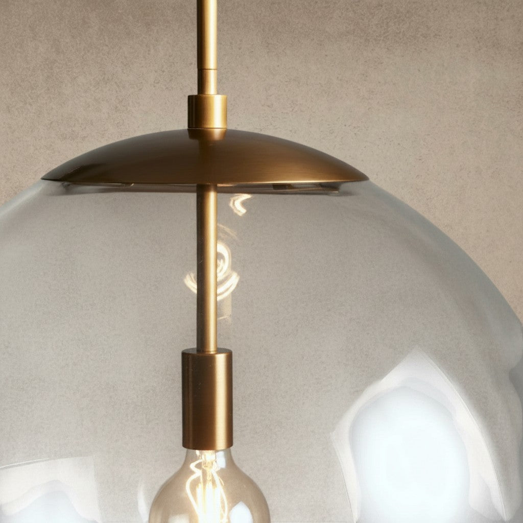 ichandelier Wescott XL Globe Pendant with brass finish and clear glass shade, featuring an exposed Edison bulb.