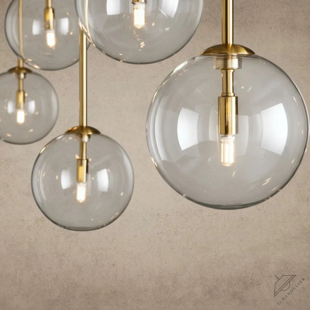 ichandelierHere 60”/72” Roscoe Linear Chandelier, clear glass globes with brass accents and exposed bulbs.